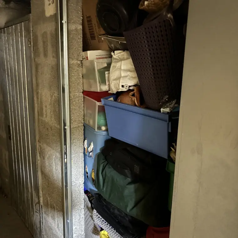 Local de stockage encombré de cartons, bacs et sacs empilés