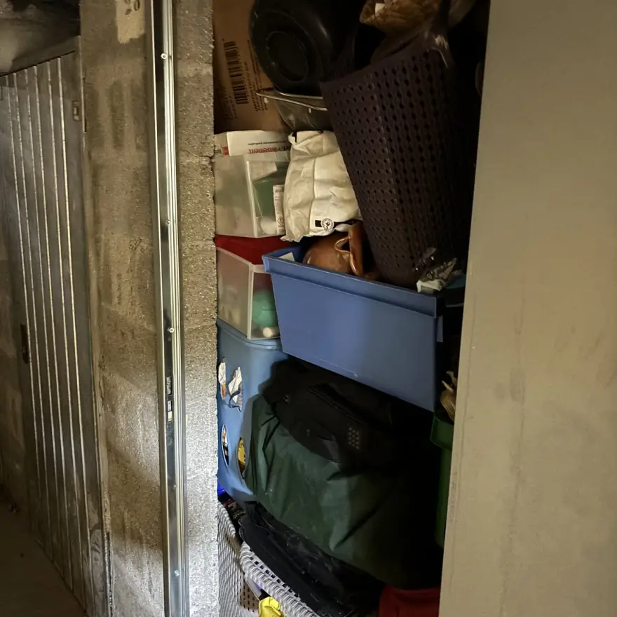 Local de stockage encombré de cartons, bacs et sacs empilés